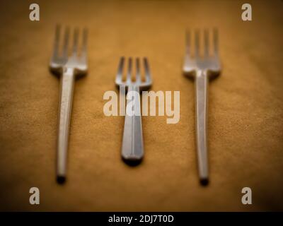 disposable tableware, red spoons forks knives on a yellow background top view Stock Photo