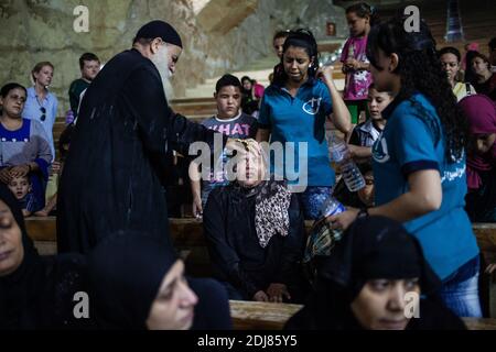 NO WEB/NO APPS - Padre Samaan Ibrahim, sacerdote copto, esegue una sessione di esorcismo presso la Chiesa di San Samaan (Simon), nota anche come Chiesa della Grotta nel villaggio di Mokattam, soprannominata "città della spazzatura", al Cairo, in Egitto, il 19 agosto 2016. Una volta alla settimana centinaia di musulmani si riuniscono nella chiesa dopo la preghiera, per assistere ad una sessione di esorcismo eseguita dal sacerdote. Con una croce e acqua Santa combatte entità spirituali e demoni. Il monastero ha un anfiteatro con una capacità di 20,000 posti a sedere che lo rende la più grande chiesa cristiana in Medio Oriente. Prende il nome dal santo copto, SIM Foto Stock