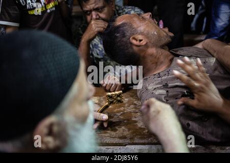 NO WEB/NO APPS - Padre Samaan Ibrahim, sacerdote copto, esegue una sessione di esorcismo presso la Chiesa di San Samaan (Simon), nota anche come Chiesa della Grotta nel villaggio di Mokattam, soprannominata "città della spazzatura", al Cairo, in Egitto, il 19 agosto 2016. Una volta alla settimana centinaia di musulmani si riuniscono nella chiesa dopo la preghiera, per assistere ad una sessione di esorcismo eseguita dal sacerdote. Con una croce e acqua Santa combatte entità spirituali e demoni. Il monastero ha un anfiteatro con una capacità di 20,000 posti a sedere che lo rende la più grande chiesa cristiana in Medio Oriente. Prende il nome dal santo copto, SIM Foto Stock