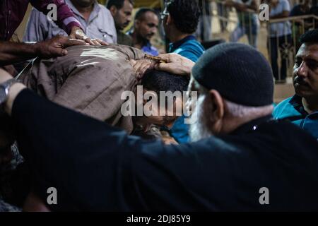 NO WEB/NO APPS - Padre Samaan Ibrahim, sacerdote copto, esegue una sessione di esorcismo presso la Chiesa di San Samaan (Simon), nota anche come Chiesa della Grotta nel villaggio di Mokattam, soprannominata "città della spazzatura", al Cairo, in Egitto, il 19 agosto 2016. Una volta alla settimana centinaia di musulmani si riuniscono nella chiesa dopo la preghiera, per assistere ad una sessione di esorcismo eseguita dal sacerdote. Con una croce e acqua Santa combatte entità spirituali e demoni. Il monastero ha un anfiteatro con una capacità di 20,000 posti a sedere che lo rende la più grande chiesa cristiana in Medio Oriente. Prende il nome dal santo copto, SIM Foto Stock