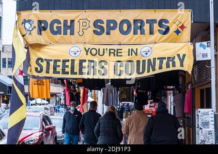 Persone di fronte a un negozio di abbigliamento sportivo e cimeli di Pittsburgh su Penn Avenue nel quartiere Strip District, Pittsburgh, Pennsylvania, USA Foto Stock