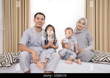 Ritratto di una famiglia felice in abiti piyama. Concetto di foto per famiglie in camera da letto Foto Stock