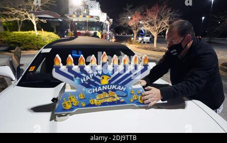 Chesterfield, Stati Uniti. 13 Dicembre 2020. Un volontario posiziona un menorah Hanukkah su un'auto, preparandosi per la sfilata Hanukkah a Chesterfield, Missouri, domenica 13 dicembre 2020. Quasi 100 automobili sfilano attraverso il quartiere di Chesterfield, Missouri, con i menorah lampanti in plastica sulle loro auto, e la musica Hanukkah che suona sulle loro radio. Photo by Bill Greenblatt/UPI Credit: UPI/Alamy Live News Foto Stock