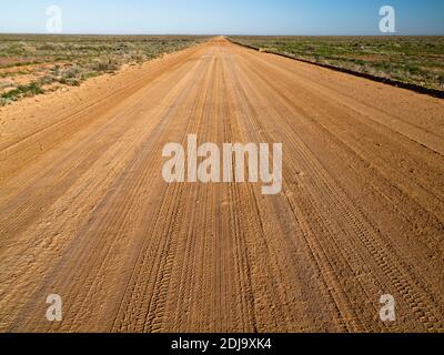 Le piste di pneumatici lungo la strada non sigillata di William Creek tagliano attraverso il deserto verso Coober Pedy. Foto Stock