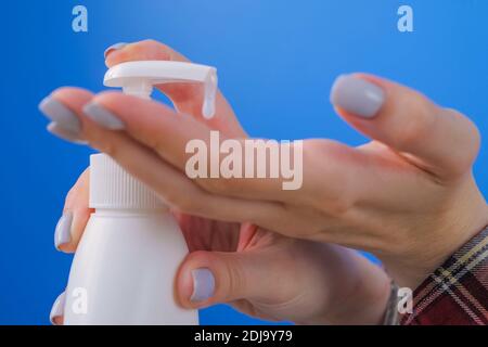 Donna che strizza il gel antisettico sul palmo, pulendo le mani - primo piano Foto Stock