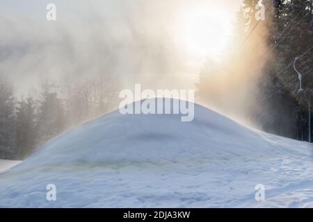 La retroilluminazione mediante la neve spray da un cannone di neve Foto Stock