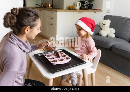 Madre con bambino che prepara i biscotti di festa a casa. Buon tempo in famiglia insieme Foto Stock