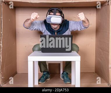 dipendente con occhiali di realtà virtuale che lavora nel cartone di casa ufficio Foto Stock