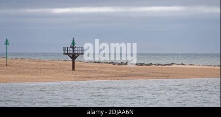 Le boe di navigazione verdi e Marker al lato Nord del Porto di Montrose sullo spiedo di spiaggia sabbiosa ad alta marea. Foto Stock