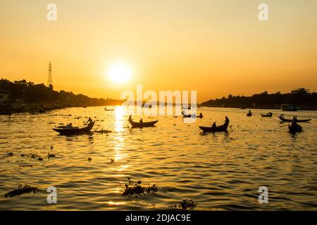 Vista magica e panoramica sul fiume Buriganga al tramonto. Centinaia di barche attraversano il fiume principale di Dhaka creando una panoramica silhouette retroilluminato Foto Stock