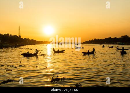 Vista magica e panoramica sul fiume Buriganga al tramonto. Centinaia di barche attraversano il fiume principale di Dhaka creando una panoramica silhouette retroilluminato Foto Stock