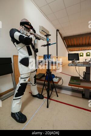 Sparatutto professionale con fucile d'aria sportivo e attrezzatura tecnica, durante l'allenamento al poligono di tiro. Sistema di destinazione elettronico. Foto Stock