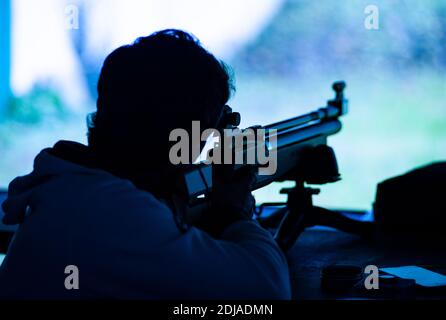 Sparatutto non identificato con fucile d'aria sportivo prende mira, durante l'allenamento al campo di tiro. Foto Stock