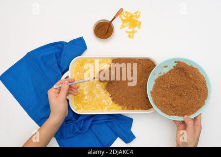 Ricetta dettagliata per la vacanza di Hanukkah, una tradizionale torta Kugel con tagliatelle e crema pasticcera, briciole di sabbia in cima. Ingredienti nei piatti su a. Foto Stock