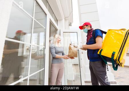 uomo di consegna con zaino termico e donna d'affari in ufficio Foto Stock