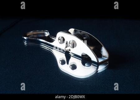 L'affilatura del coltello dagli acciai poggia su turn blu il tavolo con riflessione. Accessori da cucina su sfondo nero Foto Stock