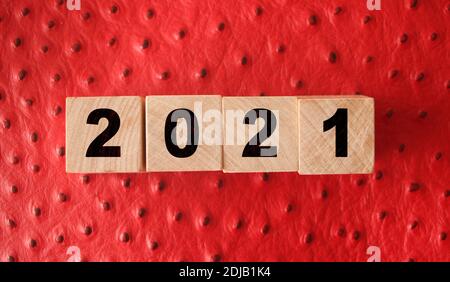2021 nuovo anno su cubetti di legno su fondo di pelle rossa. Concetto di radulazione NY. Foto Stock