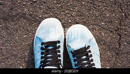 Scarpe sportive blu sneakers sul marciapiede in giornata di sole. Foto Stock