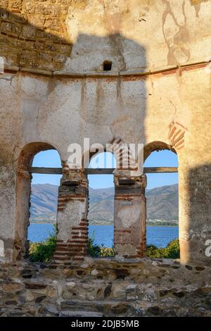 Lago Mikri Prespa visto attraverso le rovine del 10 secolo della Basilica di San Achilleios sull'isola di Agios Achilleios sul lago Mikri Prespa, Macedonia, N Foto Stock