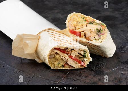 Shawarma orientale tradizionale in cartone ecologico. Superficie in pietra scura. Concetto di pacchetti ecologici di riciclabili. Spazio di copia Foto Stock