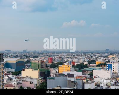 Vista dei distretti di Tan Binh e Phu Nhuan nella città di ho Chi Minh, Vietnam. Un Vietnam Airlines Airbus A350 può essere visto avvicinarsi Tan Son Nhat Internation Foto Stock