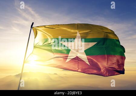 Bandiera del Myanmar che sventola sulla nebbia all'alba Foto Stock