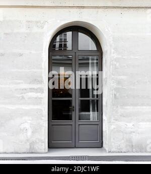 Nuova porta a doppia anta in legno grigio ad arco. Cancello di legno - ingresso. Vintage vecchio grigio porta in pietra muro in cemento casa Parigi Francia. Raccolto quadrato Foto Stock