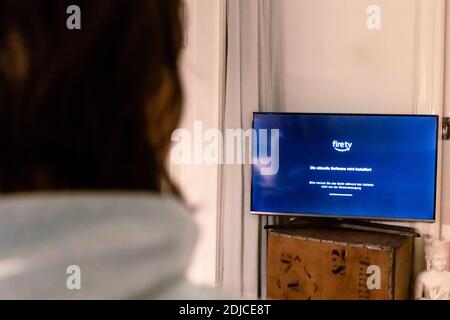 Una donna segue il processo di installazione del suo TV Stick Sulla sua TV Foto Stock