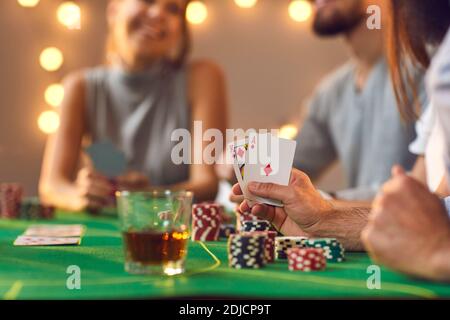 ACE e il re aka Big Slick in mano dell'uomo seduto al tavolo delle carte tra amici che giocano a poker Foto Stock