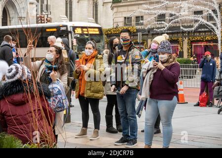 I turisti per scattare delle foto al Rockefeller Center di fronte all'albero di Natale Vista e tutta da Saks Fifth Avenue, New York, Stati Uniti d'America Foto Stock