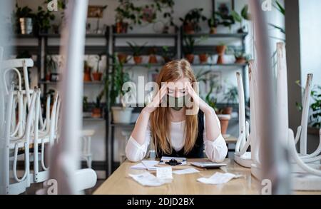 Il direttore è stato frustrato seduto al tavolo in un caffè chiuso, mentre la piccola azienda si è chiusa a causa del coronavirus. Foto Stock
