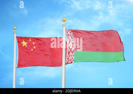 Cina e Bielorussia due bandiere su paletti e blu nuvoloso cielo Foto Stock