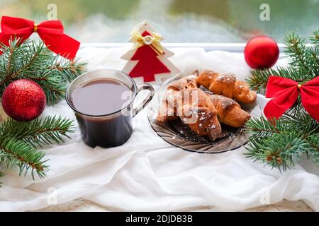 Tazza di caffè con latte e biscotti davanzale con albero di natale e decorazioni Foto Stock