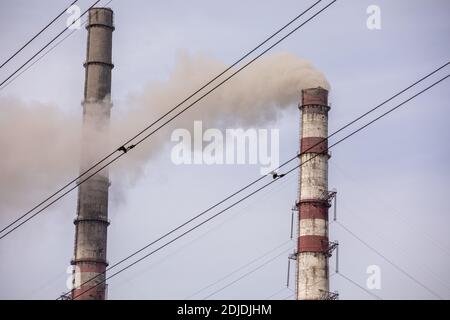 Fumo da due camini industriali, tubi, contro il cielo. Riscaldamento globale. Inquinamento atmosferico. Inquinamento ecologico. Emissioni di aria che inquinano la città. IND Foto Stock