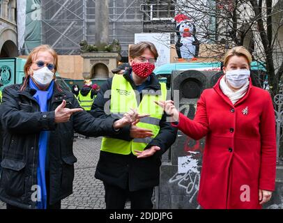14 dicembre 2020, Berlino: Il cantante Frank Zander (l-r), suo figlio Marcus Zander e Franziska Giffey (SPD), Ministro federale della famiglia, anziani, donne e giovani, stanno di fronte alla distribuzione di cibo caldo per i senzatetto nella parrocchia cattolica di S. Marien Liebfrauen, nella Wrangelstraße di Kreuzberg. Zander e la sua famiglia sostengono i camion di cibo per i senzatetto e i bisognosi dalla Caritas e Diakonie. A causa della pandemia di Corona, la sua tradizionale festa di Natale per i senzatetto e i bisognosi all'Estrel Hotel deve essere cancellata quest'anno. Foto: Jens Kalaene/dpa- Foto Stock