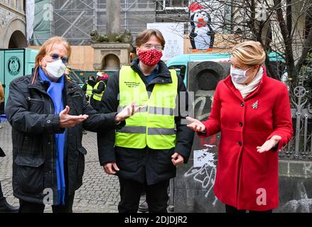 14 dicembre 2020, Berlino: Il cantante Frank Zander (l-r), suo figlio Marcus Zander e Franziska Giffey (SPD), Ministro federale della famiglia, anziani, donne e giovani, stanno di fronte alla distribuzione di cibo caldo per i senzatetto nella parrocchia cattolica di S. Marien Liebfrauen, nella Wrangelstraße di Kreuzberg. Zander e la sua famiglia sostengono i camion di cibo per i senzatetto e i bisognosi dalla Caritas e Diakonie. A causa della pandemia di Corona, la sua tradizionale festa di Natale per i senzatetto e i bisognosi all'Estrel Hotel deve essere cancellata quest'anno. Foto: Jens Kalaene/dpa- Foto Stock