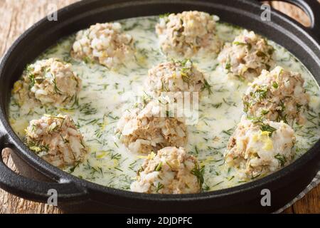 Yuvarlakia è un piatto greco di polpette condite con un Avgolemono o salsa di limone d'uovo primo piano in un piatto sul tavolo. Orizzontale Foto Stock