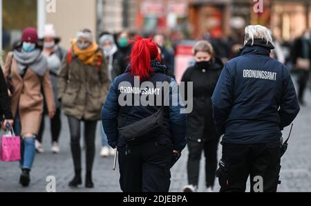 14 dicembre 2020, Sassonia-Anhalt, Halle (Saale): Il personale dell'ufficio dell'ordine pubblico cammina attraverso una strada dello shopping a Halle/Saale. Oggi il governo della Sassonia-Anhalt si riunisce per decidere il blocco a partire da mercoledì. Foto: Hendrik Schmidt/dpa-Zentralbild/dpa Foto Stock