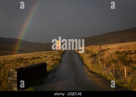 Arcobaleno sulla strada di montagna Foto Stock