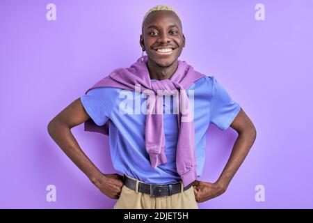 allegro afro maschio in camicia casual che si posa alla macchina fotografica, sorridente, con un sorriso toothy, isolato su sfondo viola Foto Stock