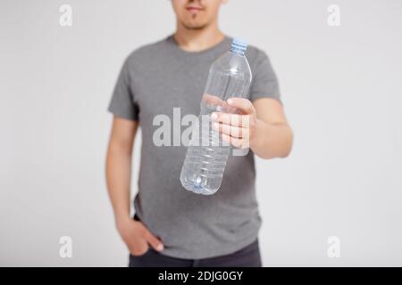 concetto di riciclaggio e smistamento rifiuti - flacone in plastica maschio passa lo sfondo grigio con lo spazio per la copia Foto Stock