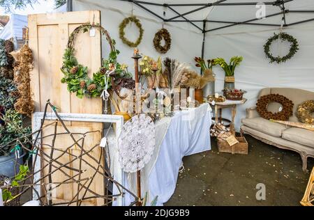 Ghirlande, fiori secchi e effimera in esposizione per la vendita in uno stalli alla fiera invernale di Brocante Paese in Piazza del mercato, Midhurst, Sussex occidentale Foto Stock