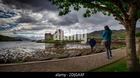 La mattina presto la luce del sole oltre il Castello Eilean Donan a Kyle of Lochalsh nelle Highlands occidentali della Scozia Foto Stock