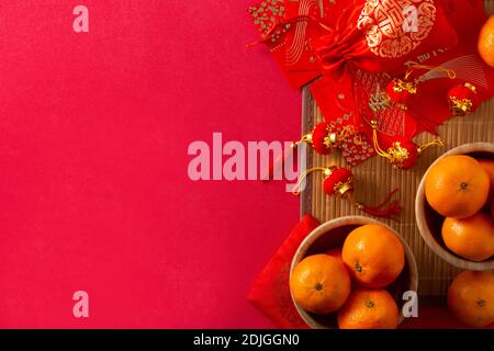 Decorazioni e arance cinesi del festival del nuovo anno su sfondo rosso Foto Stock