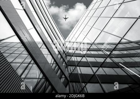 Aeromobile in volo su architettura moderna edificio, basso angolo bianco e nero immagini ad alto contrasto Foto Stock