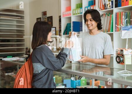 La ragazza giovane che visita un negozio di cancelleria compra la cancelleria Foto Stock