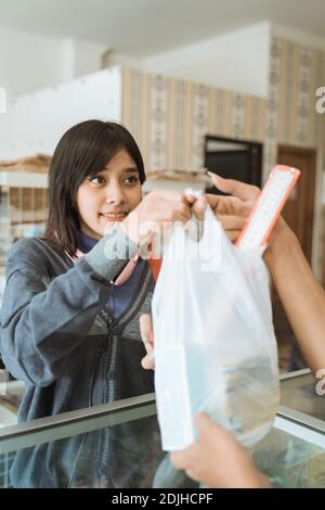 La ragazza giovane che visita un negozio di cancelleria compra la cancelleria Foto Stock