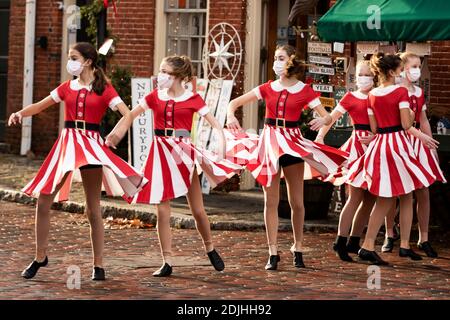 Le ragazze adolescenti eseguono una routine di ballo di Natale indossando maschere nel quartiere storico di Newburyport, Massachusetts, Stati Uniti nel dicembre 2020. Foto Stock