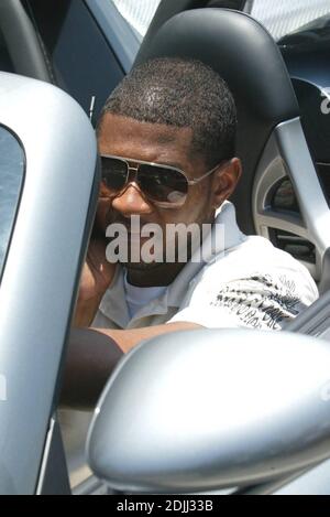 Esclusiva!! Usher viene affrettato dai tifosi che cercano di ottenere una foto della star hip-hop che esce da uno spazio di parcheggio nella sua nuova Porsche Carrera GT. Miami Beach, Florida. 05/30/06 Foto Stock