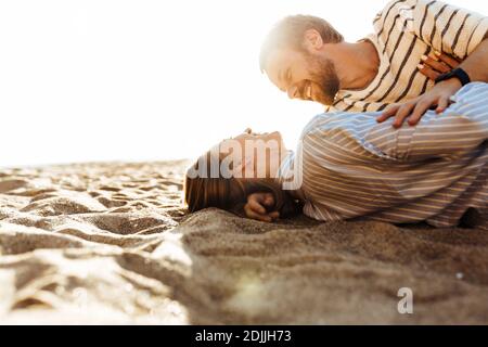 Foto di una giovane coppia giovane e affettuosa che si trova fuori il hugging spiaggia Foto Stock